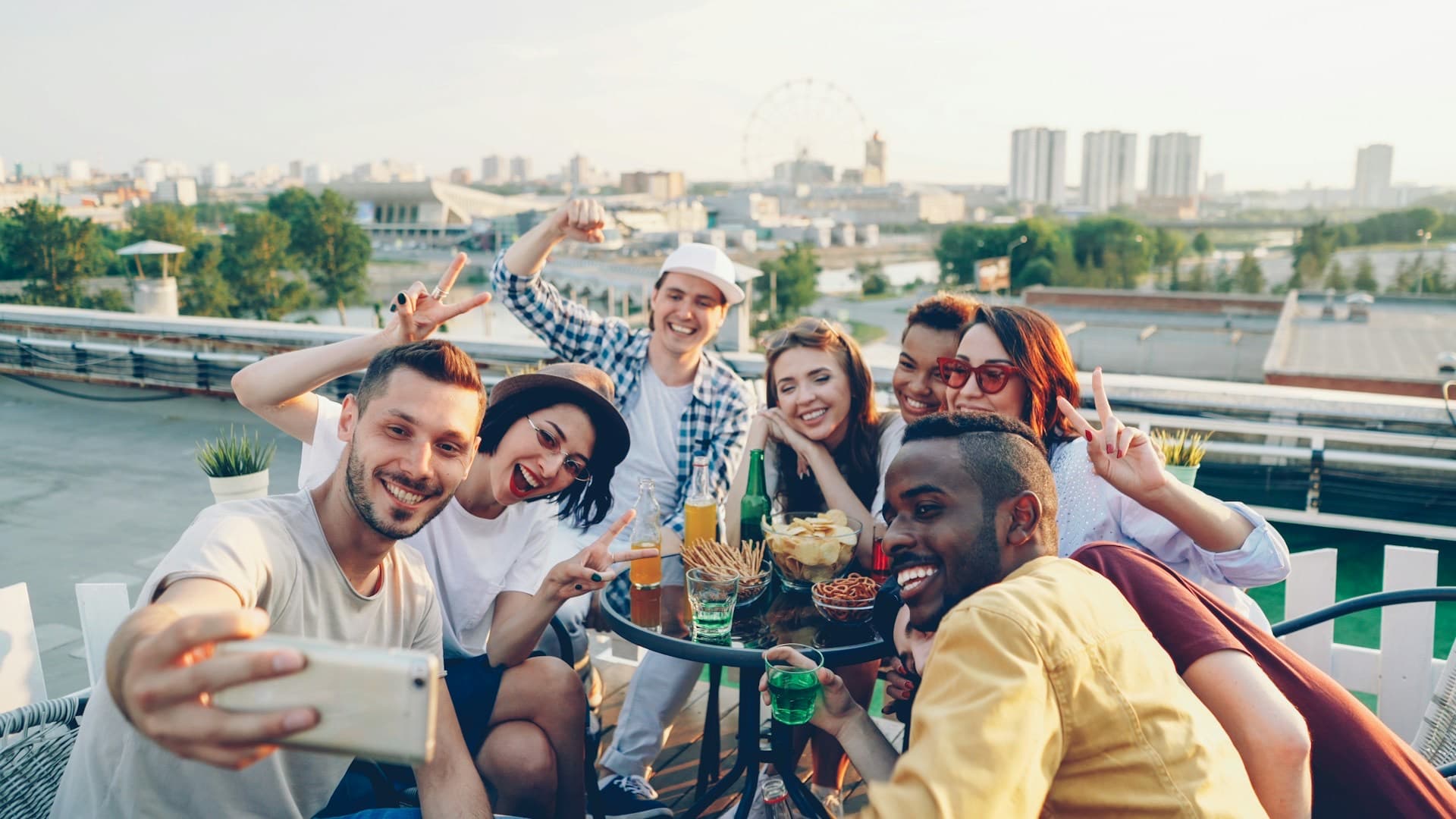 Grupo de amigos sorrindo para uma selfie em um terraço