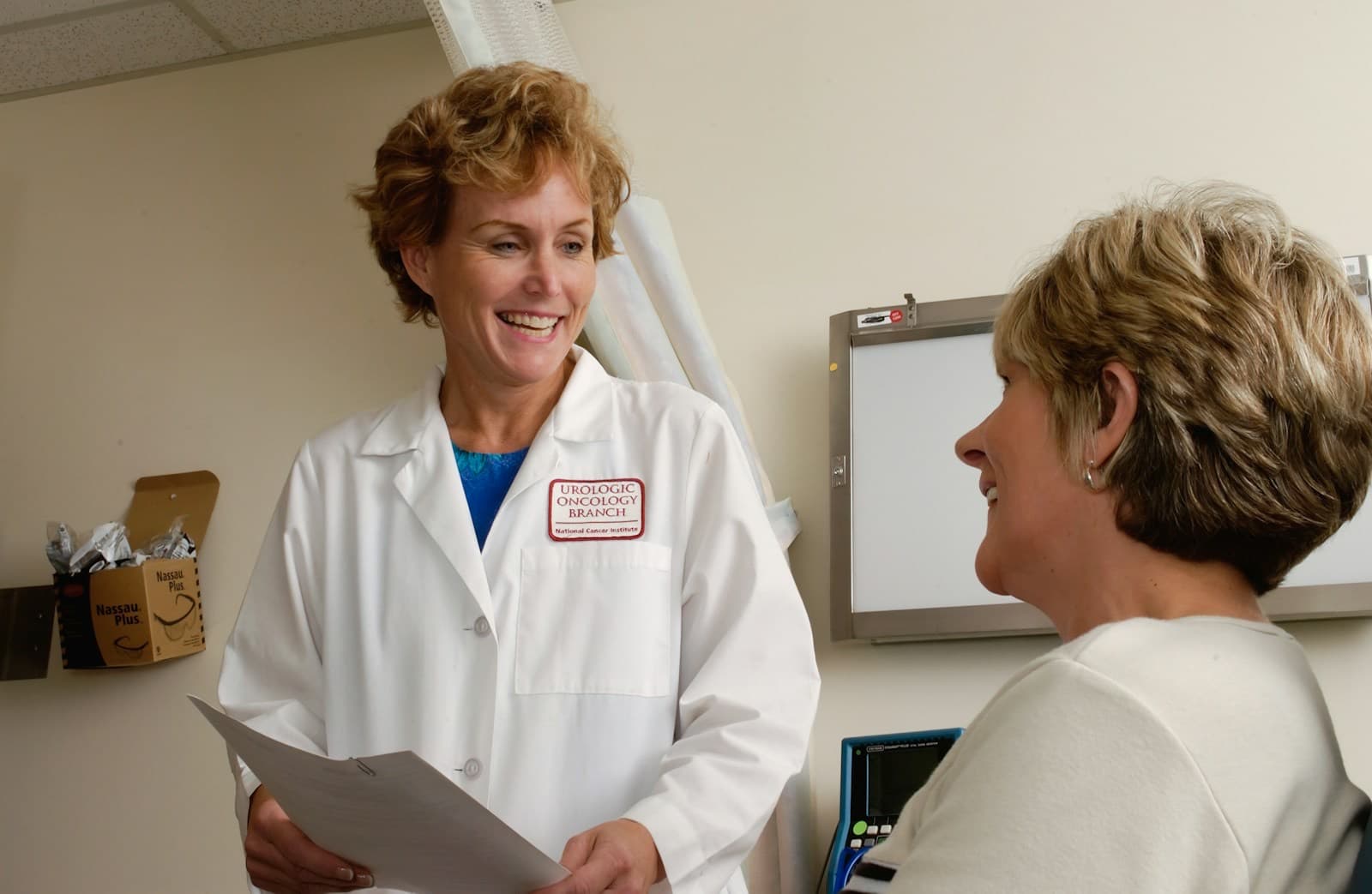 Médica sorridente conversando com uma paciente